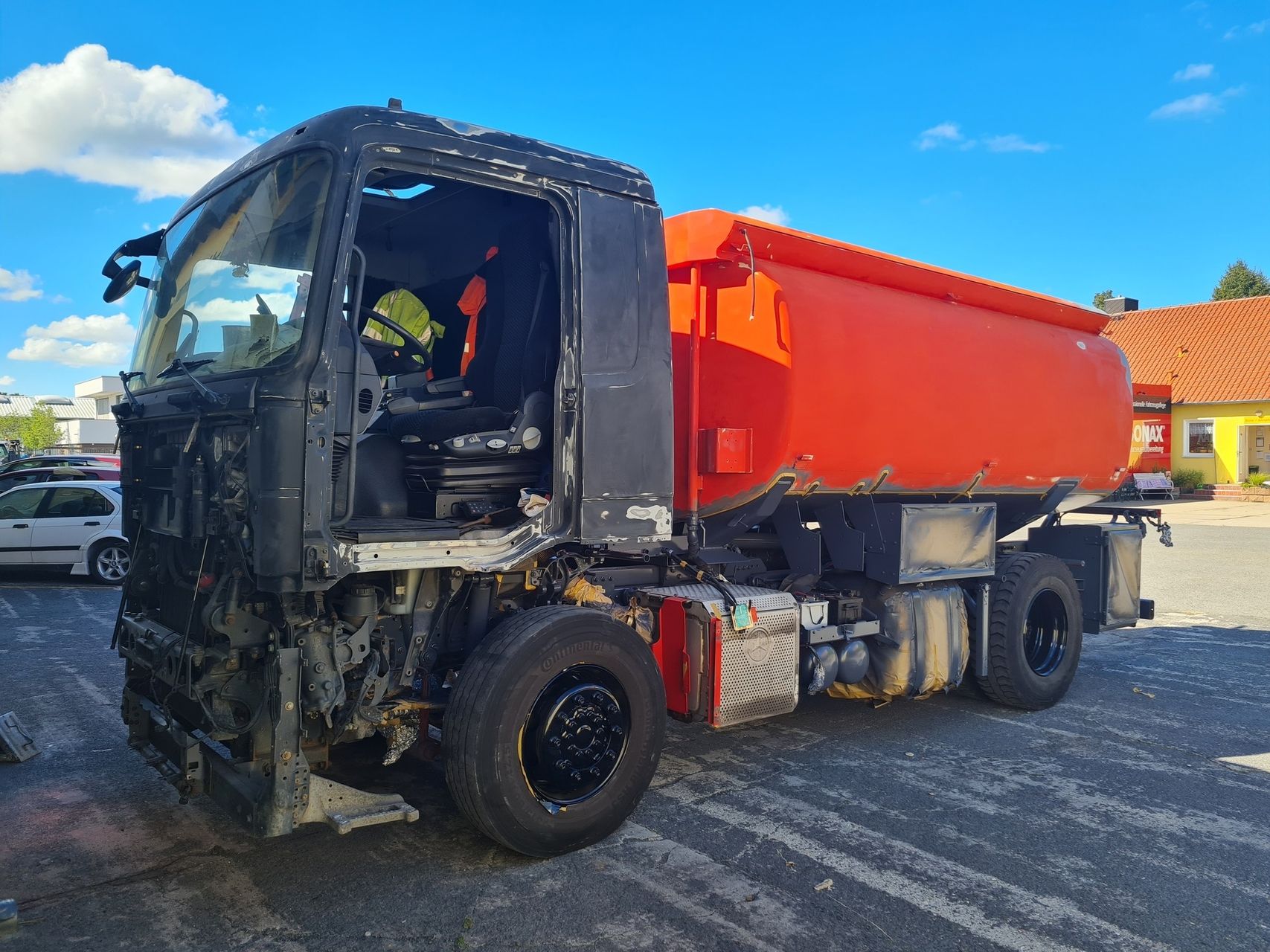 Ein roter LKW vor der Lackiererei - rohe Karosserie